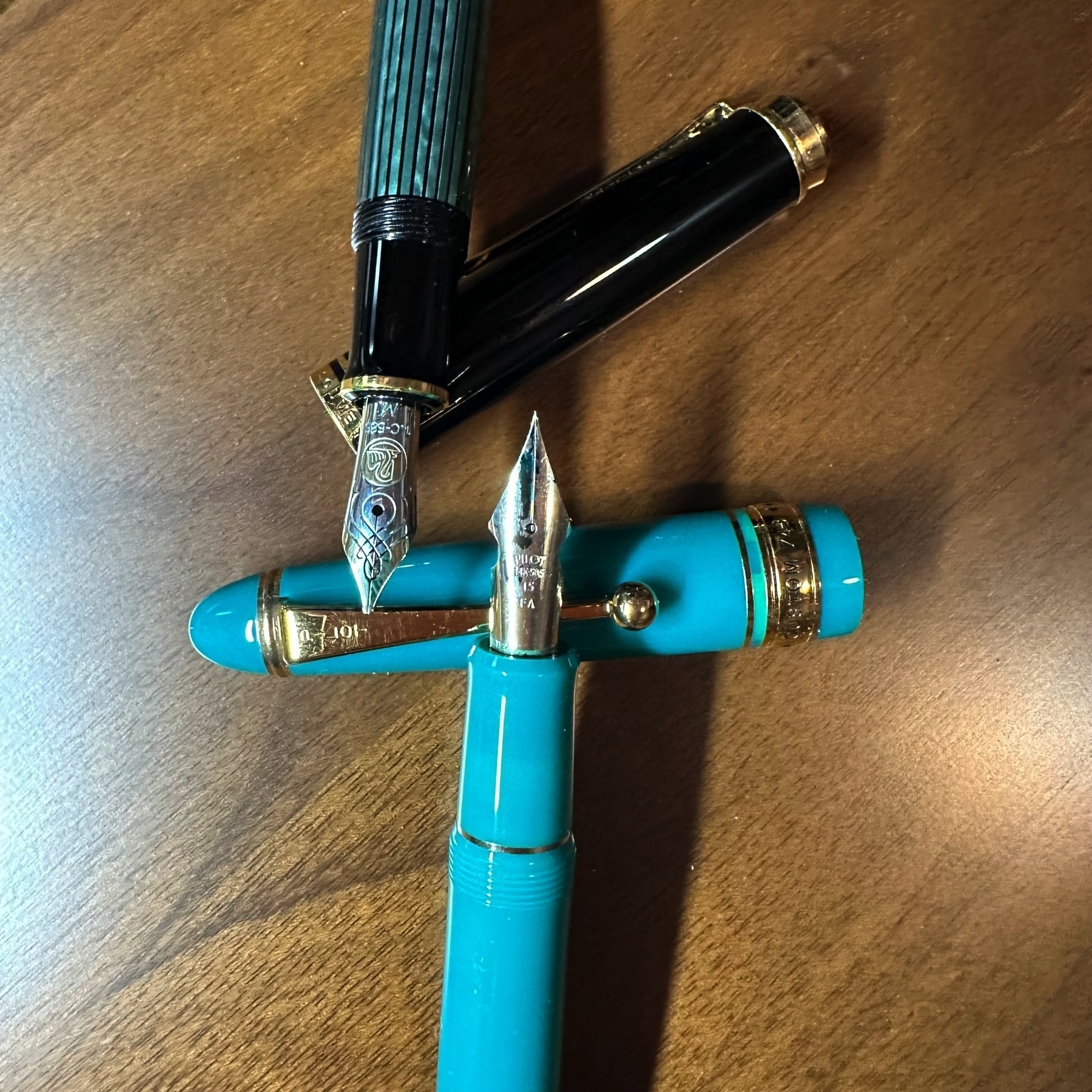 A Pelikan M600 and Pilot Custom 743 fountain pens uncapped.